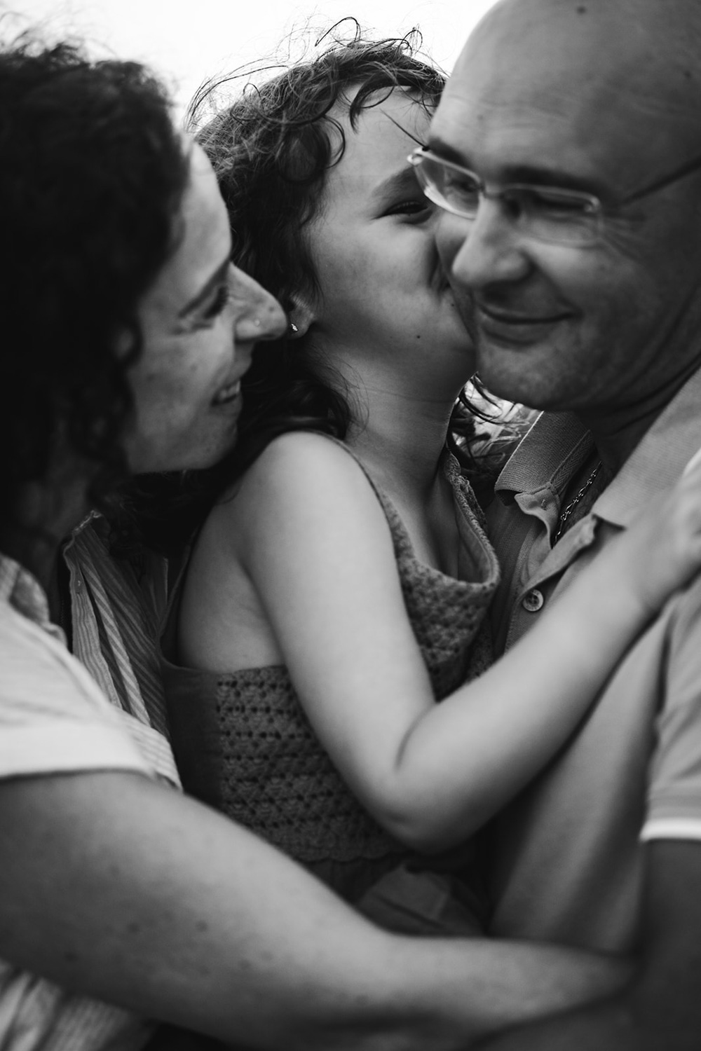 Les parents serrent leur fille dans les bras, elle embrasse son père sur la joue
