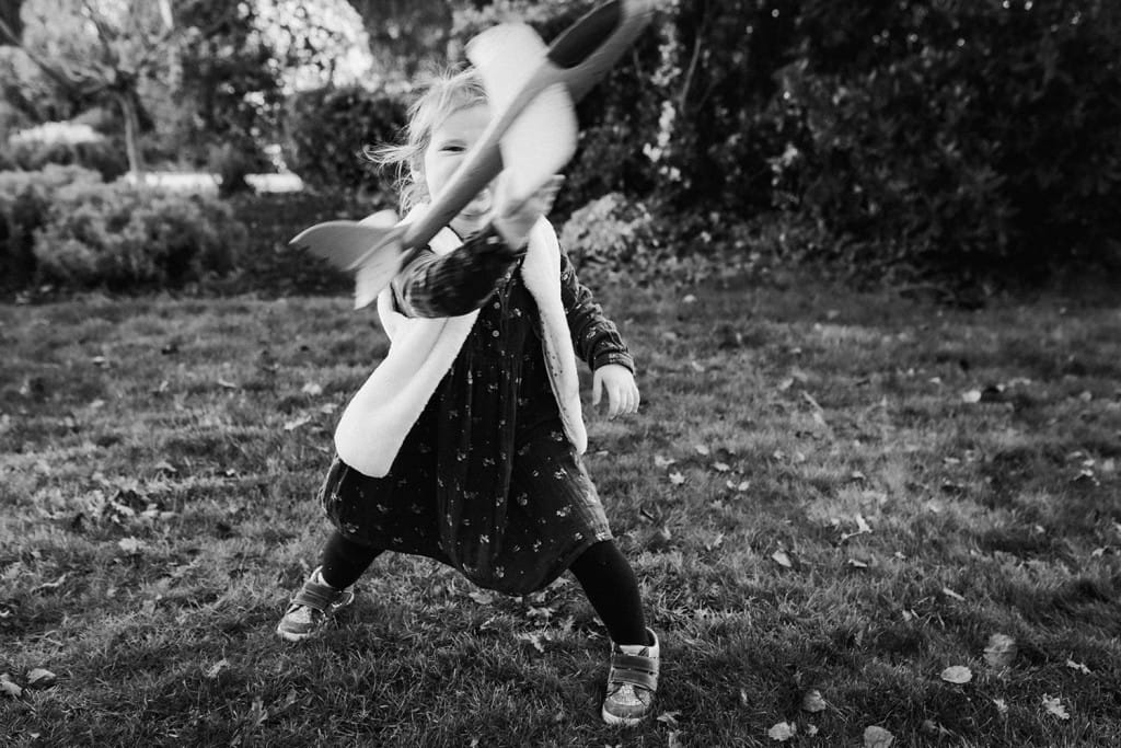 La petite fille lance un avion dans les airs lors d'une séance photo réalisée par une photographe famille landes