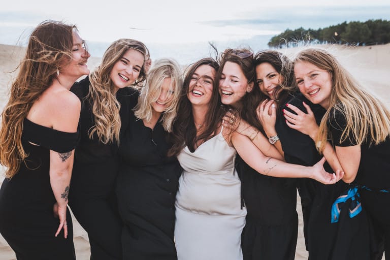 Lors d'un EVJF sur le Bassin d'Arcachon, les filles du groupe s'enlacent en riant et en regardant la photographe