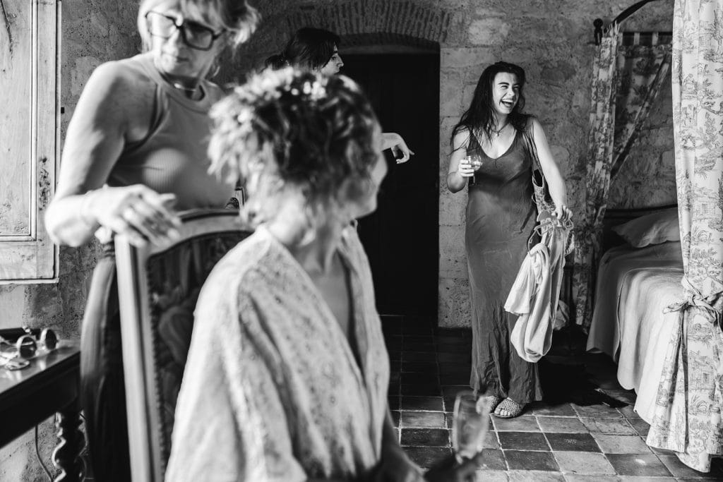 Une demoiselle d'honneur découvre la coiffure de la mariée et sourit