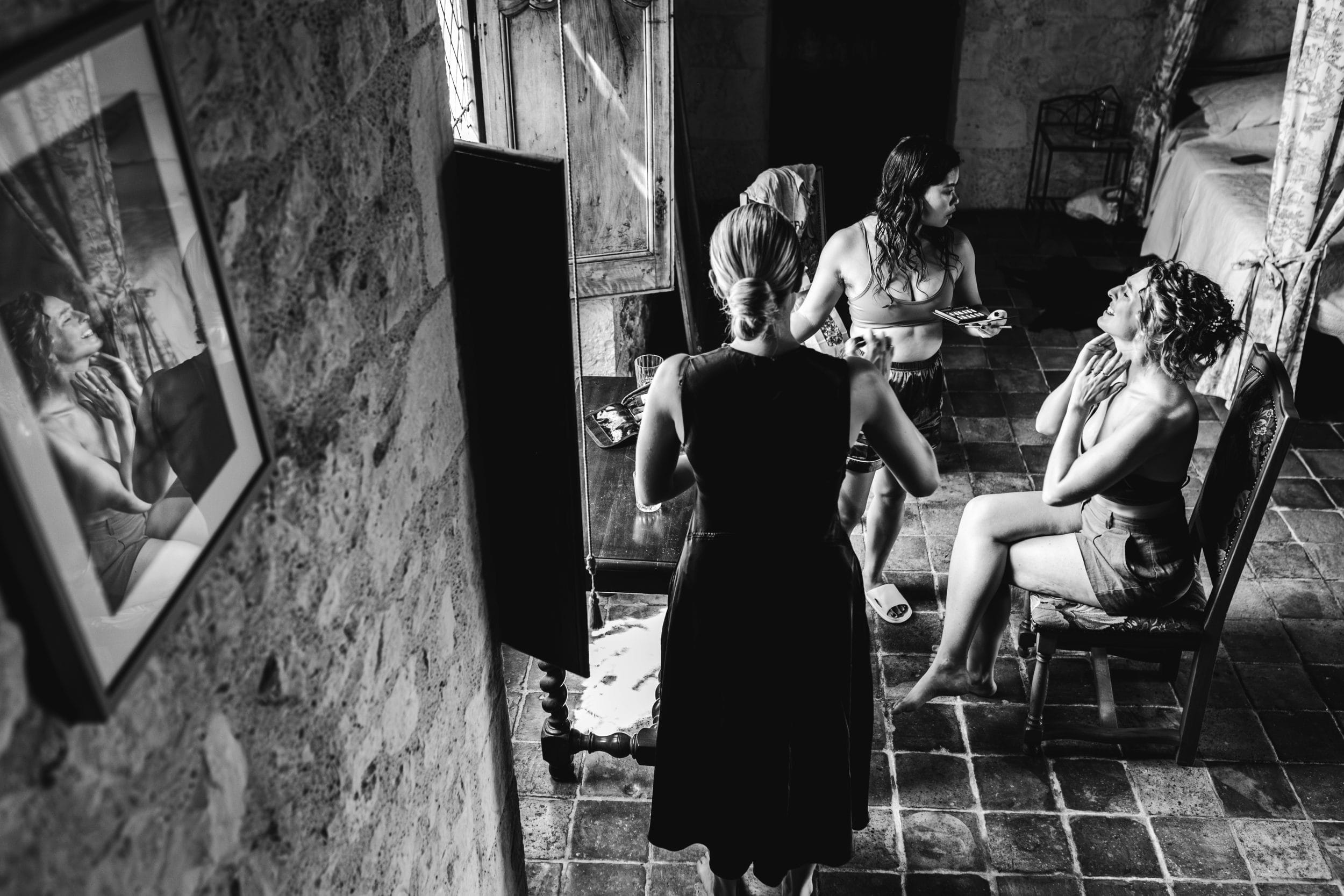 La mariée discute avec ses témoins et la coiffeuse pendant ses préparatifs de mariage
