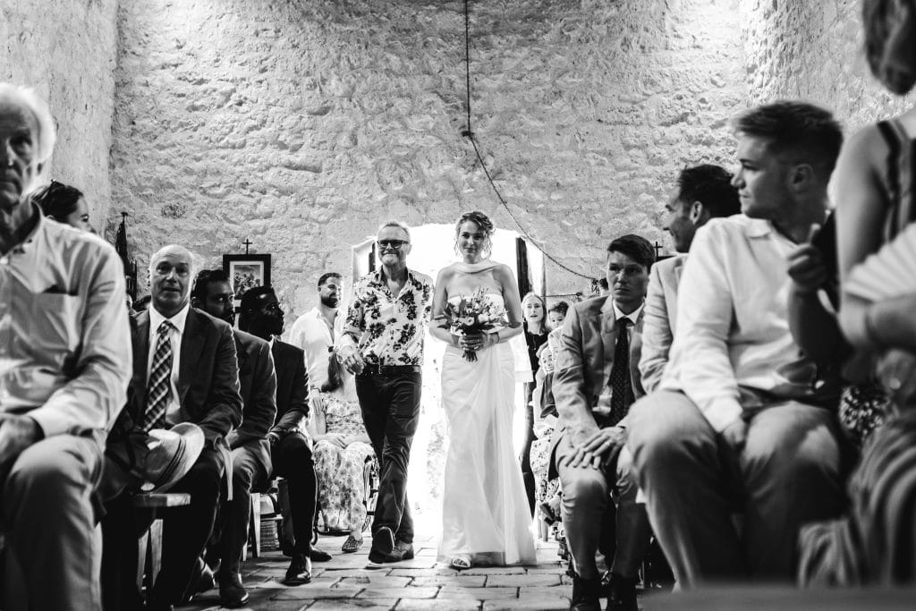 La mariée entre dans la chapelle au bras de son père et marche dans l'allée jusqu'à son futur mari