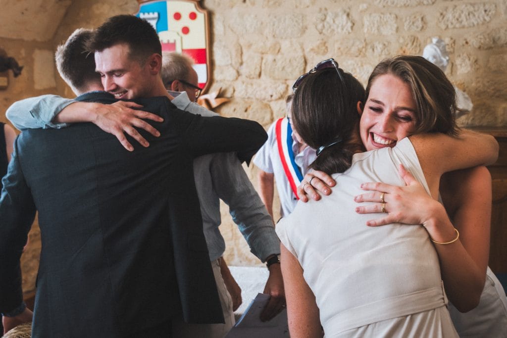 Les mariés serrent leurs familles dans leurs bras après leur cérémonie civile de mariage