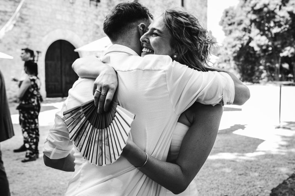 La mariée serre son amie dans ses bras durant son cocktail de mariage au château Sainte-Foy