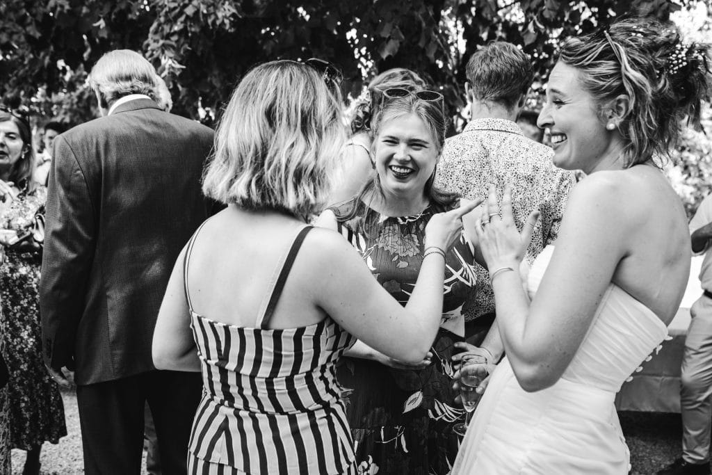 Des invités rient avec la mariée pendant le cocktail de mariage