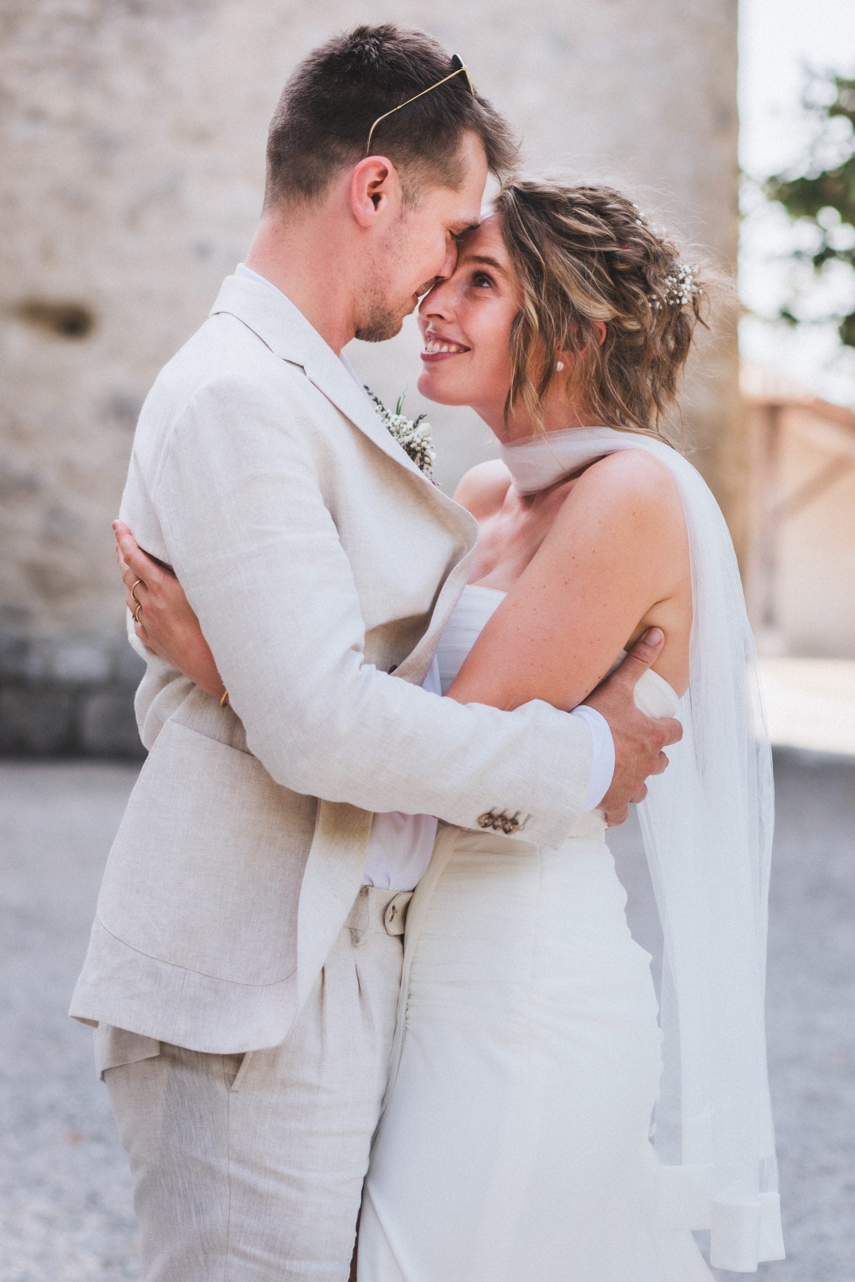 Les mariés, front contre front, se regardent amoureusement lors de leur mariage au château Sainte-Foy