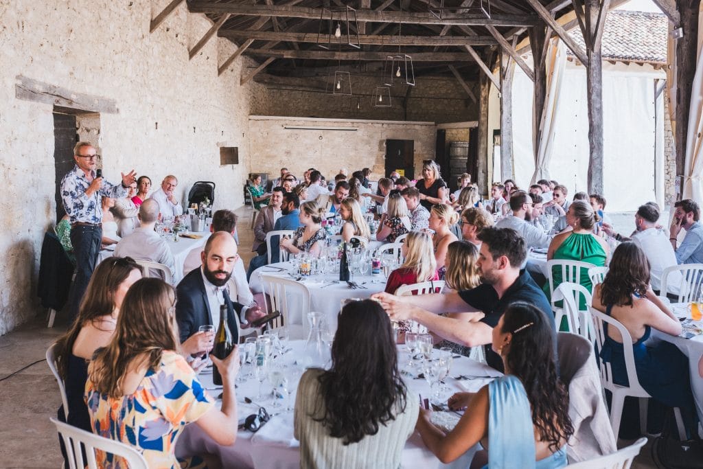 La salle lève son verre en l'honneur des mariés après le discours du papa, lors du mariage au château Sainte-Foy