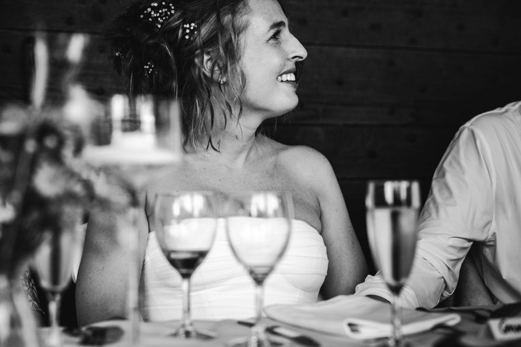 Portrait de la mariée qui écoute attentivement les discours de ses proches lors de son mariage au château Sainte-Foy