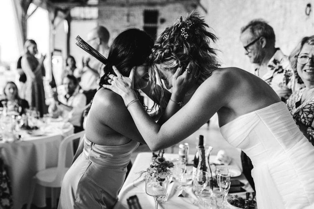 La mariée pose délicatement son front contre celui de sa témoin après son discours émouvant, lors de son mariage au château Sainte-Foy