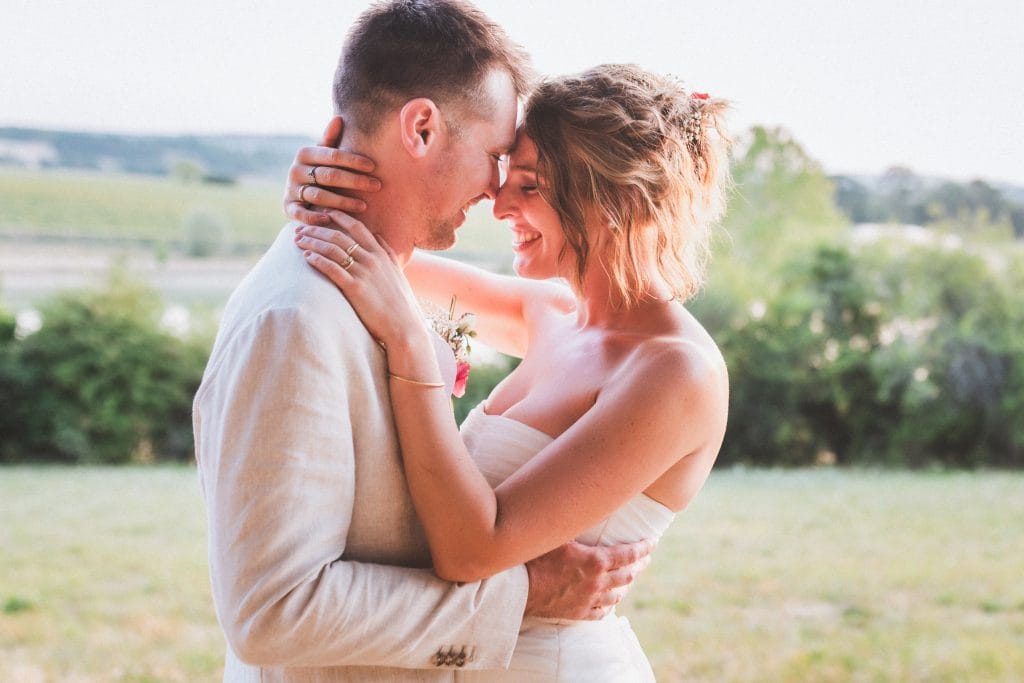 Les mariés se sourient, front contre front, pendant leur séance photo de mariage au château Sainte-Foy