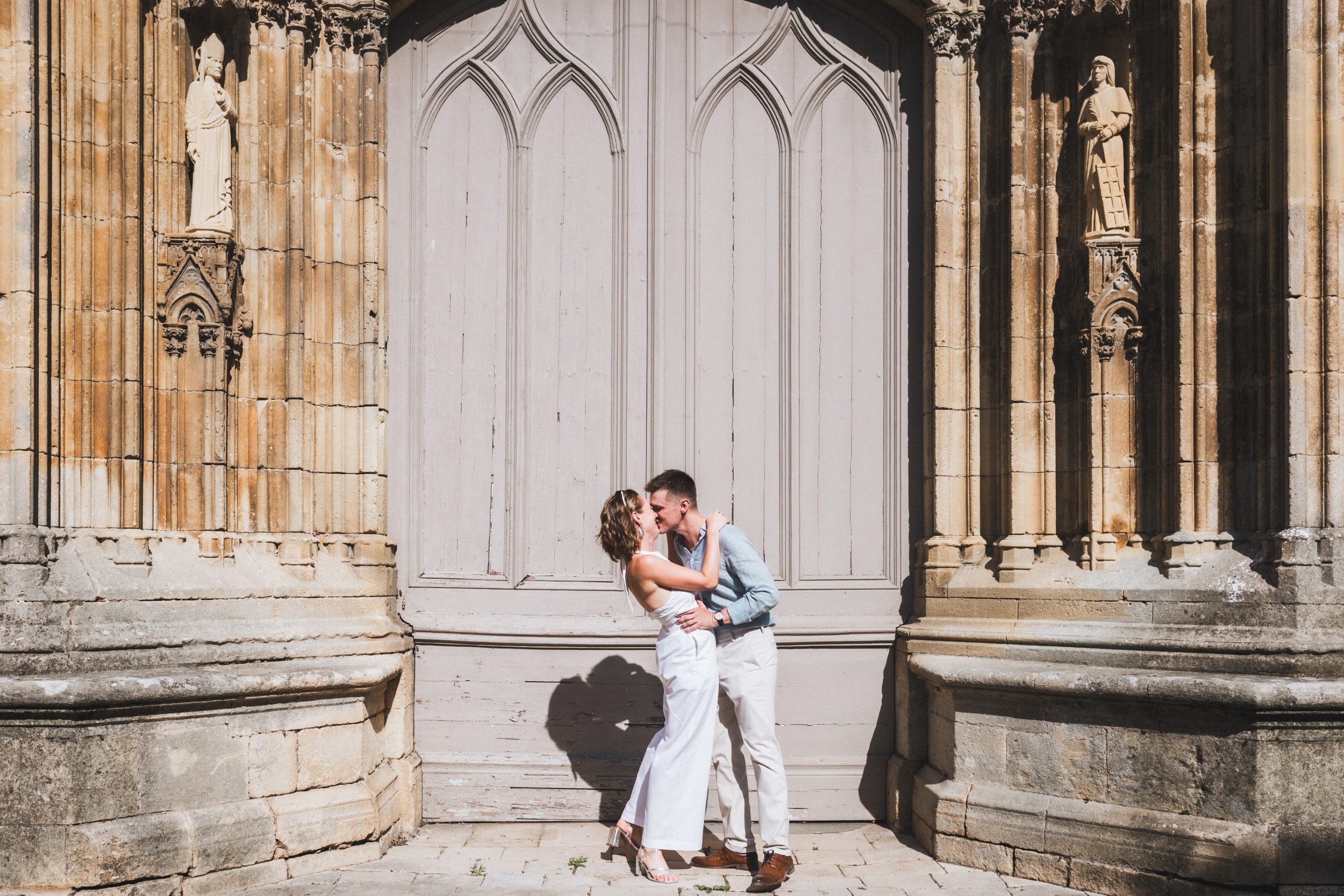 Les mariés s'embrassent devant la porte de l'église du village après leur cérémonie civile de mariage