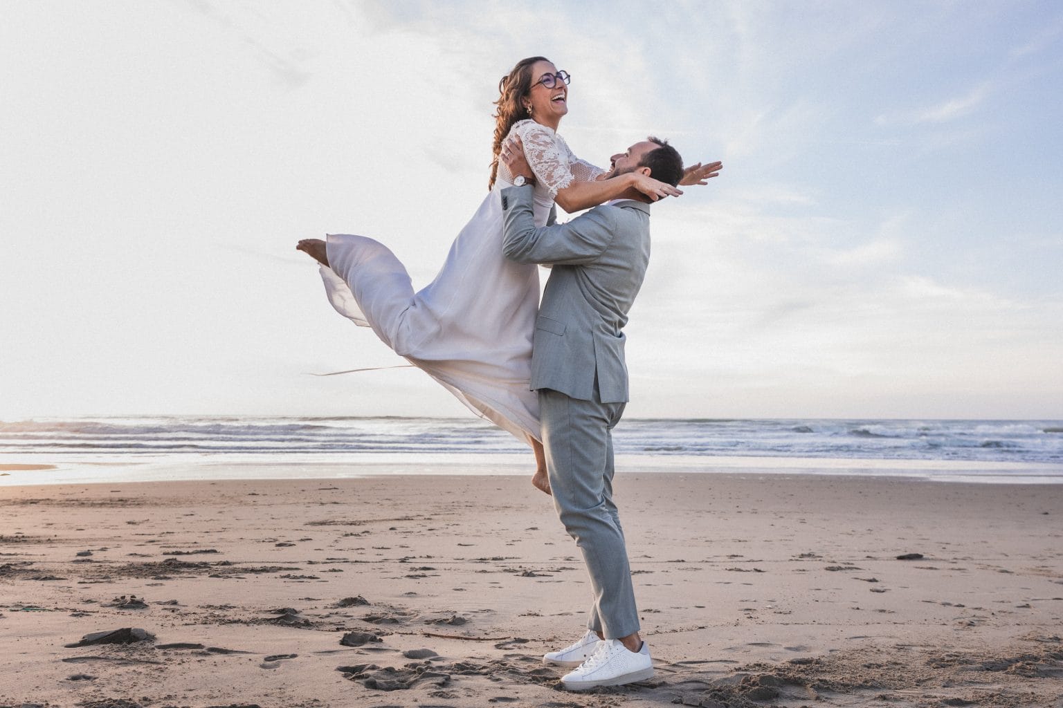 La mariée saute dans les bras du marié, qui la soulève dans les airs