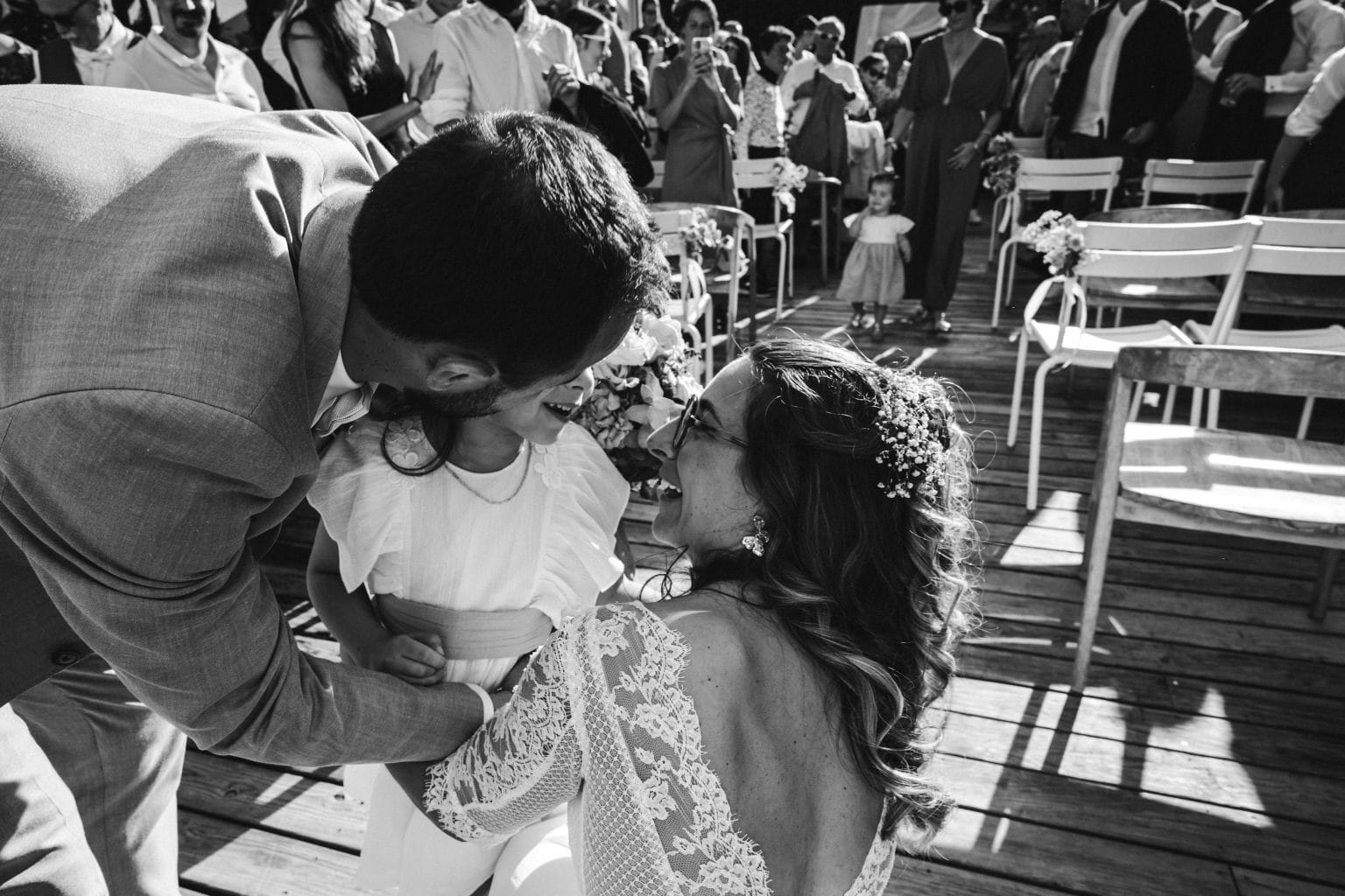 Les mariés embrassent leur fille sur la joue après la cérémonie
