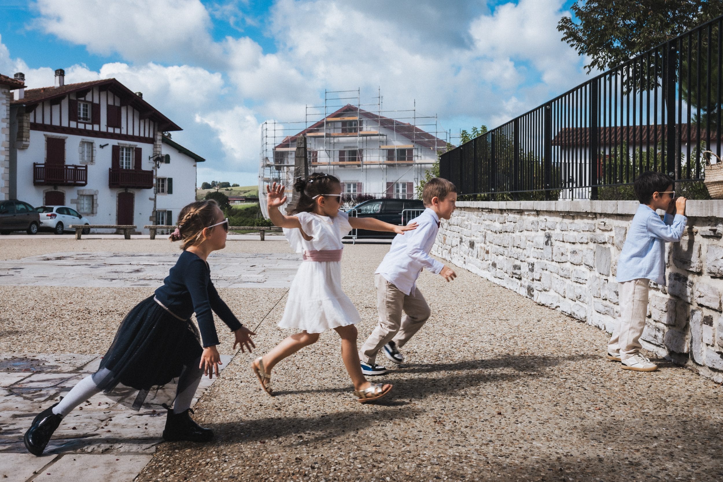 Les enfants jouent à un deux trois soleil sur le parvis de la mairie au Pays Basque