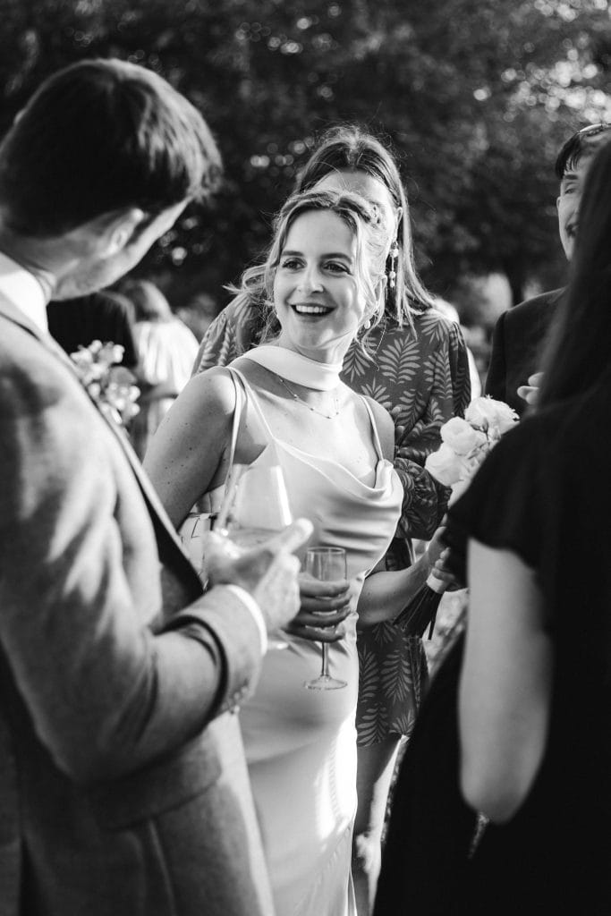 Portrait de la mariée qui sourit à ses amies durant son cocktail de mariage à Saint-Emilion