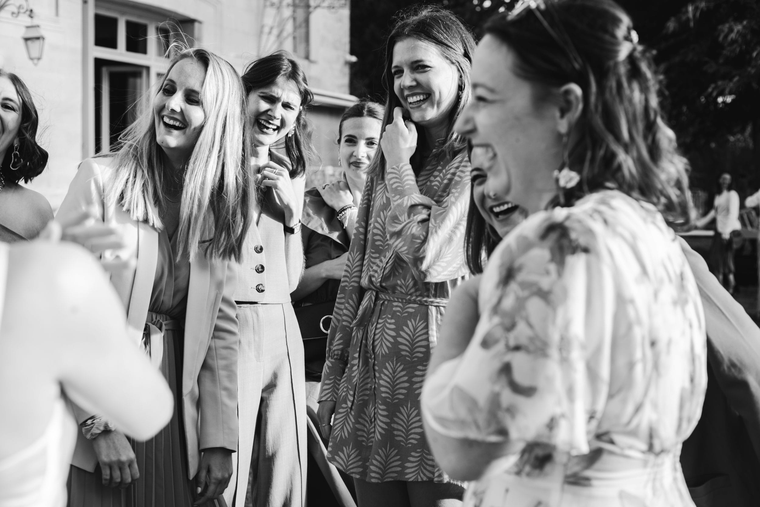 Les amies de la mariée rient après le lancer du bouquet