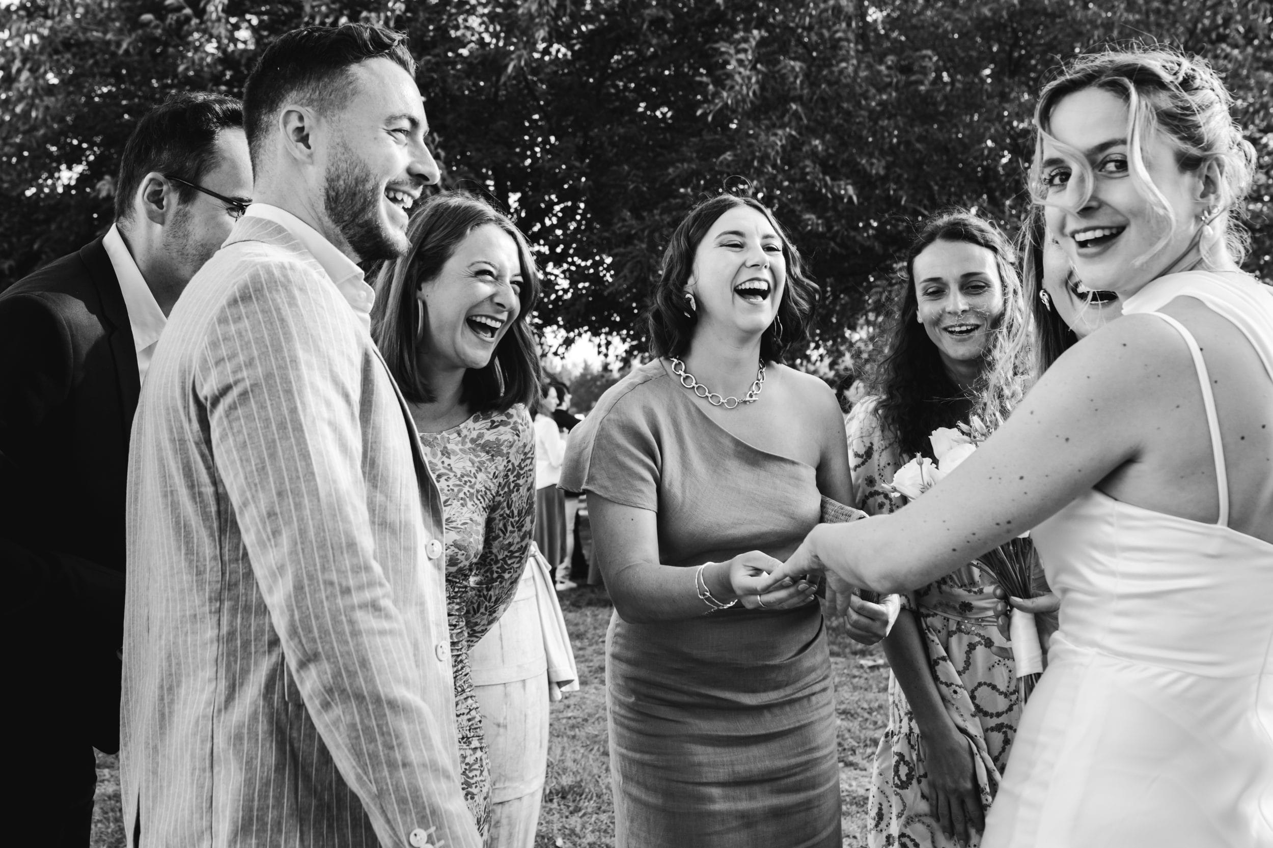 Les amies de la mariée éclatent de rire en discutant et en regardant son alliance