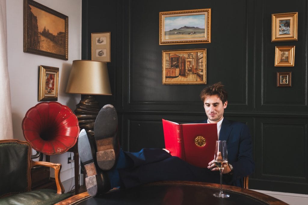 Le marié, dans le salon du château avant son mariage à Saint-Emilion, entame la lecture d'un livre, les pieds sur la table