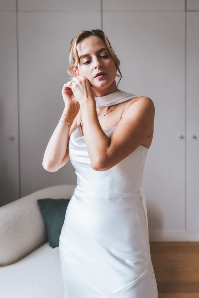 La mariée est en train de mettre ses boucles d'oreille, pendant ses préparatifs de mariage à Saint-Emilion