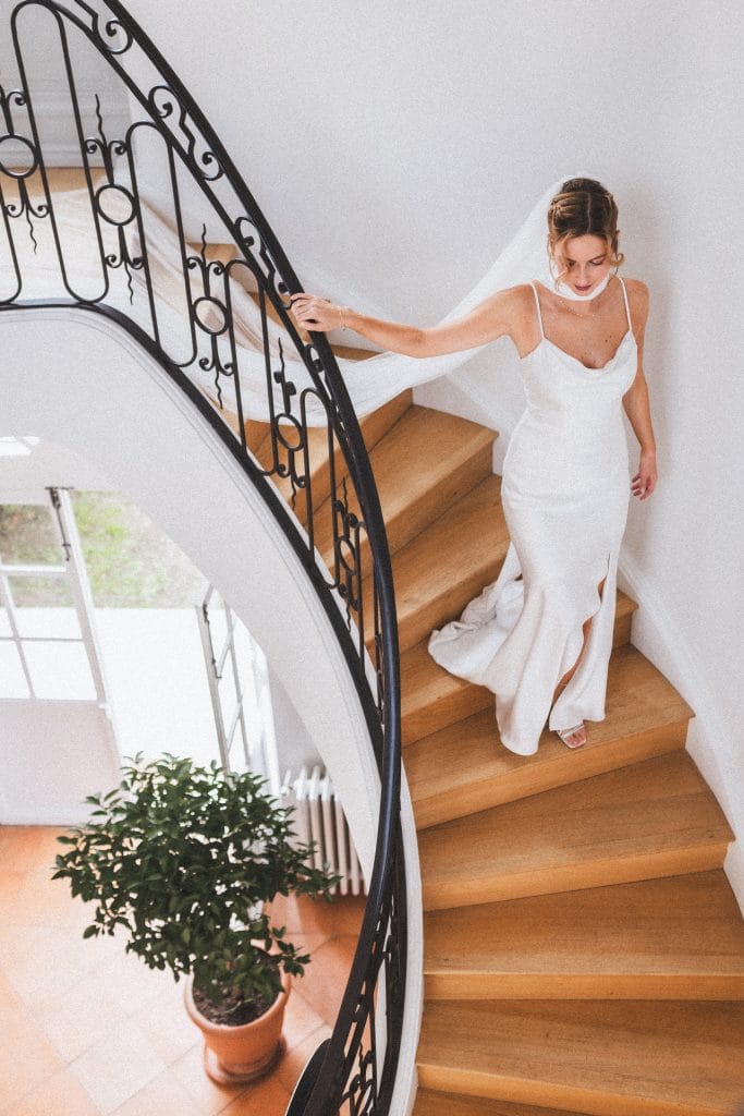 La mariée descend gracieusement l'escalier avant de se diriger vers sa cérémonie de mariage à Saint-Emilion