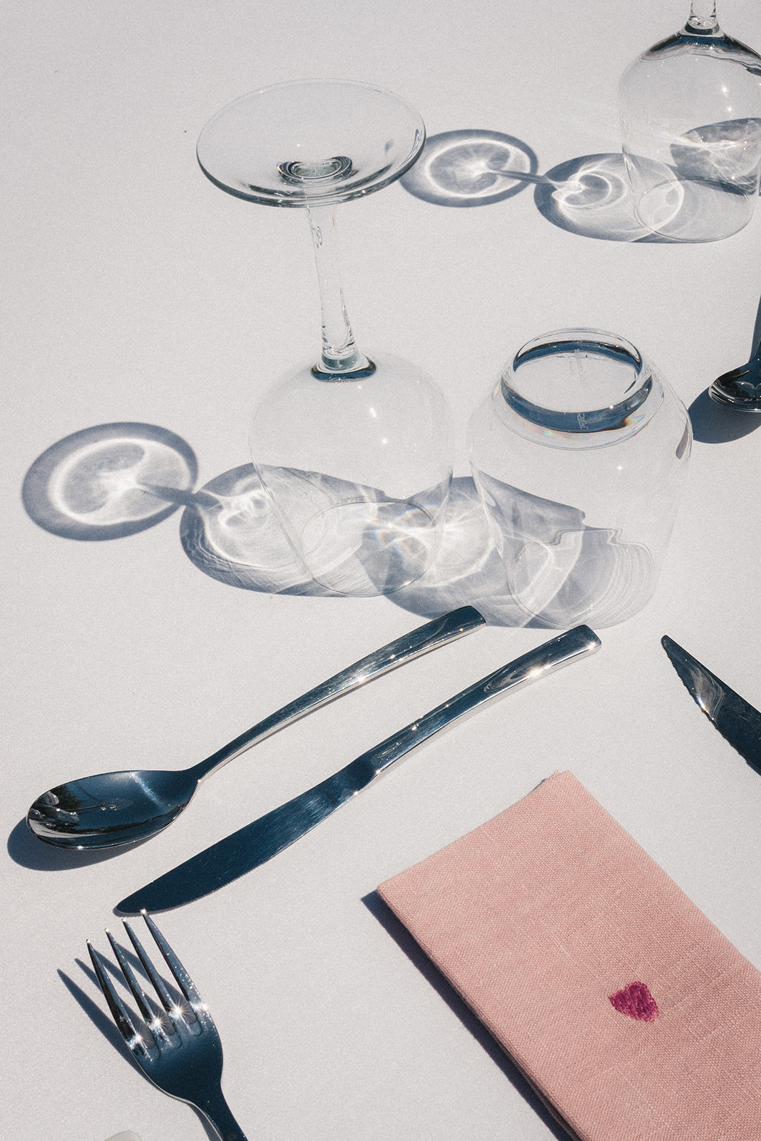 Décoration de table du mariage, avec verres à pied et serviettes roses brodées d'un coeur