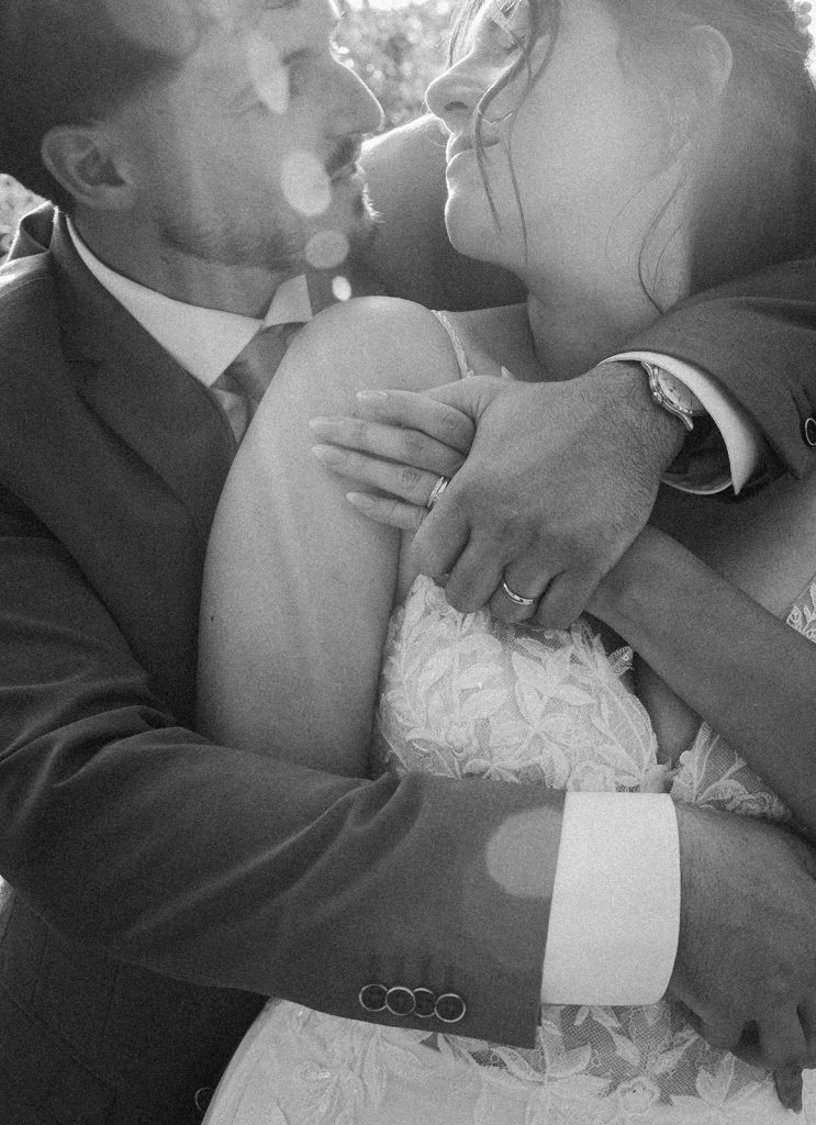 Les mariés s'enlacent tendrement pendant leur séance couple, avec le soleil en arrière plan