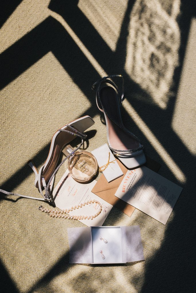 Flatlay des accessoires et de la papeterie du mariage dans un rayon de soleil