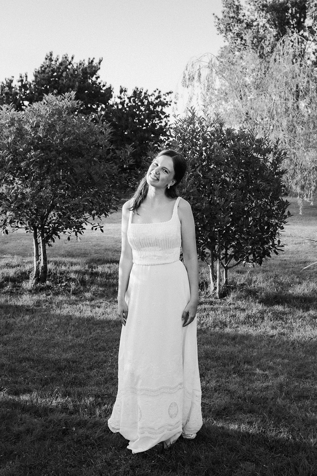 Portrait simple de la mariée en noir et blanc, qui se tient droite et regarde l'objectif