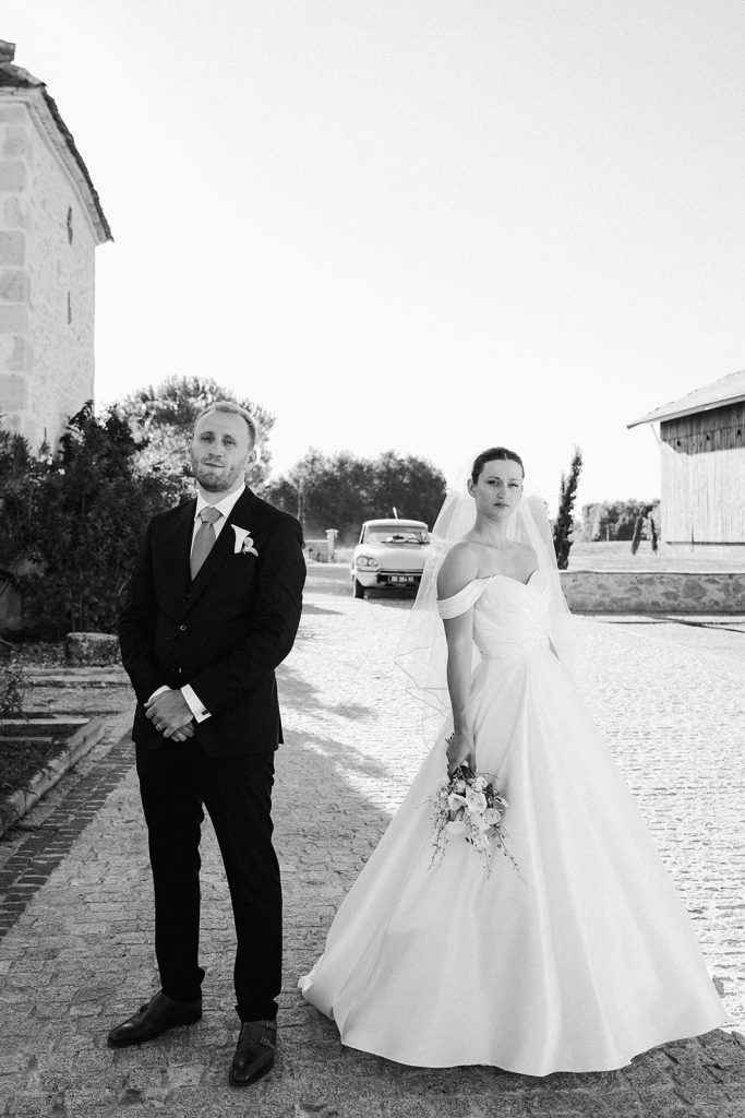 Les mariés, sérieux, regardent vers la photographe mariage Landes