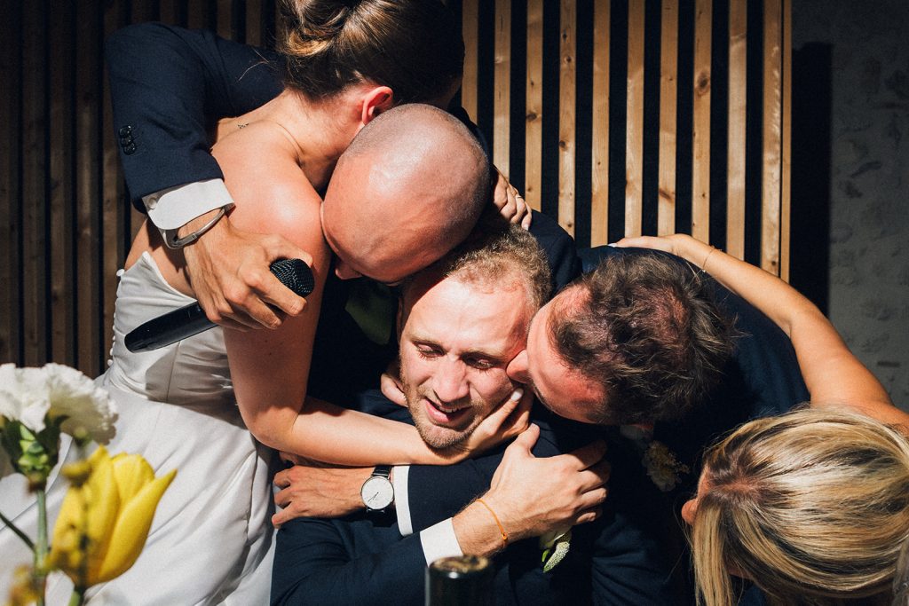 Après un discours émouvant, les témoins du marié serre ce dernier dans leurs bras